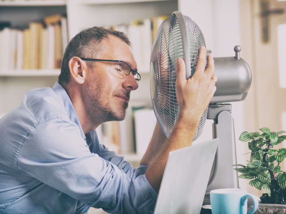 Man in front of a fan needing Summertime AC solutions.
