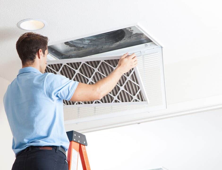 replacing your air filter- tech on a ladder